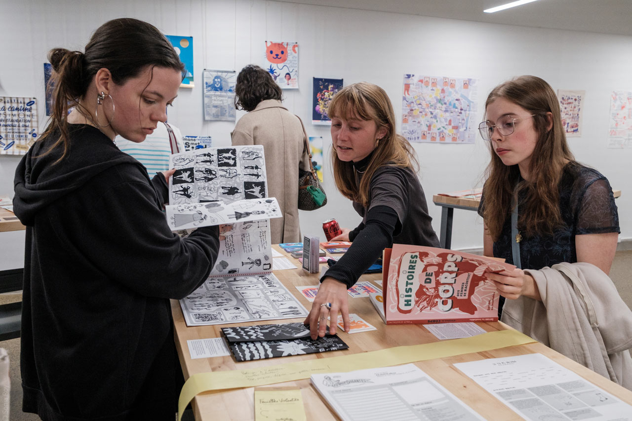 Des personnes visitent l'exposition organisée durant le colloque sur le design social à l'ÉdAC en octobre 2025.
