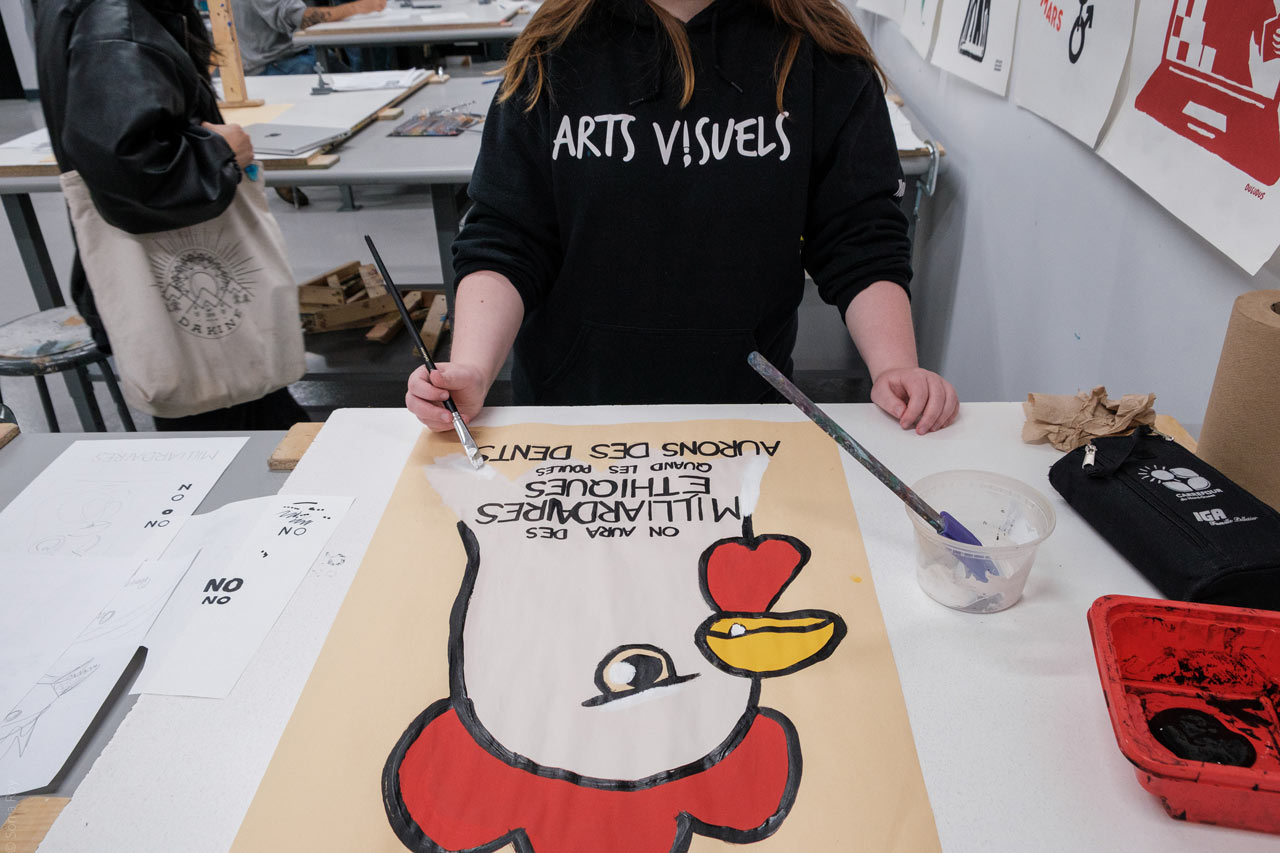 Une personne réalise une affiche dans le cadre d'un atelier de pratique durant le colloque sur le design social à l'ÉdAC en octobre 2025.