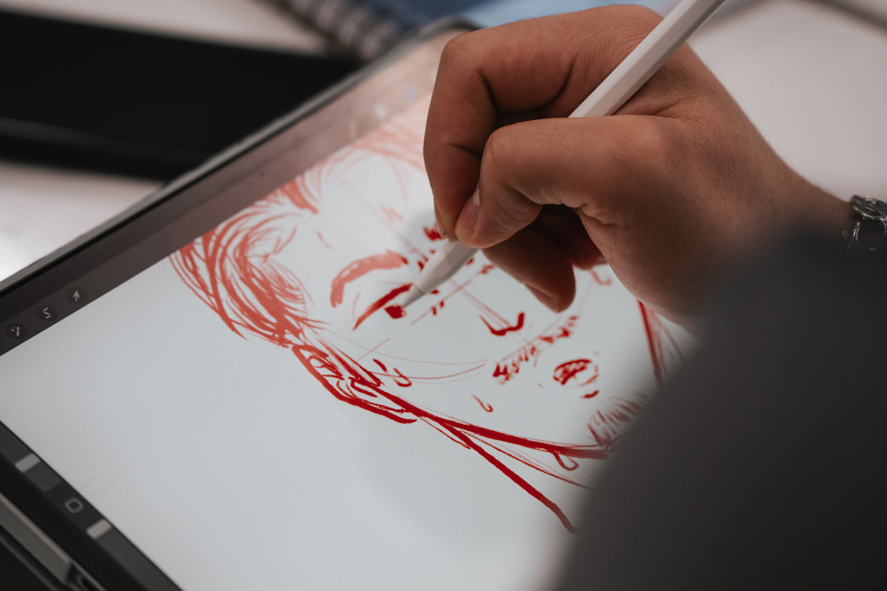 Une personne dessine sur un écran dans un atelier de création à l'ÉdAC.