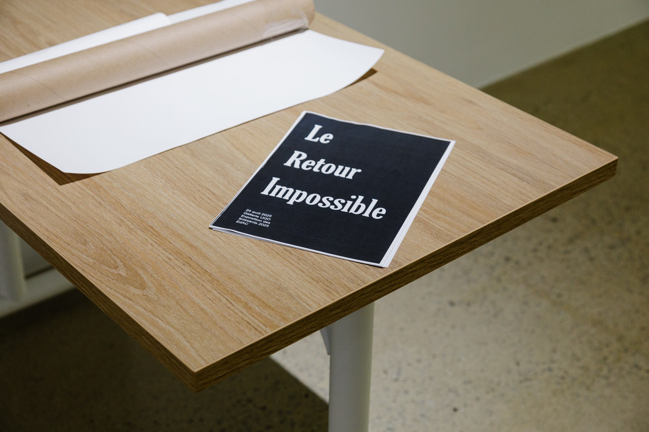 Une affiche, sur laquelle se peut lire "Le retour impossible", est posée sur une table dans le cadre d'une exposition à l'ÉdAC.