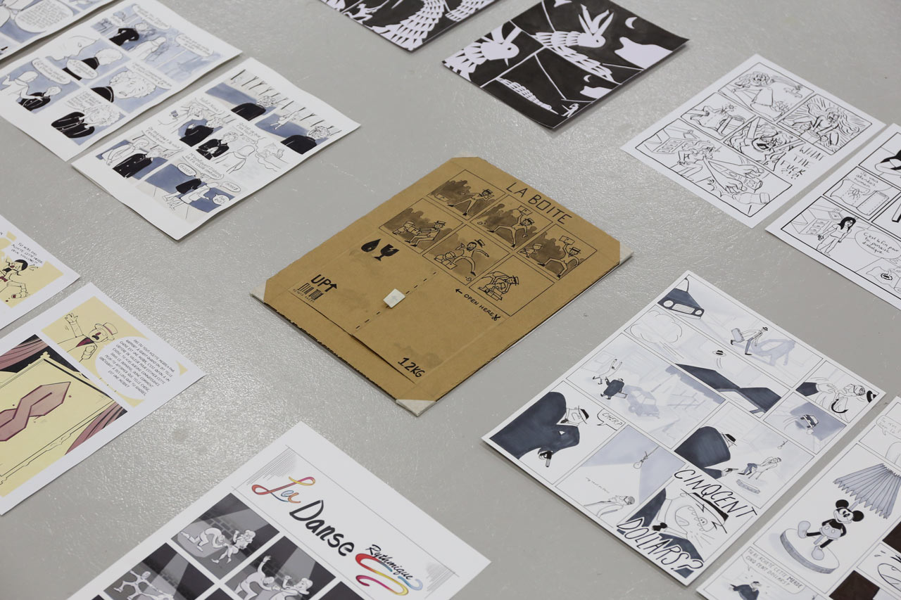 Des planches de bande dessinée sont étalées au sol pour une exposition de fin d'année à l'ÉdAC.