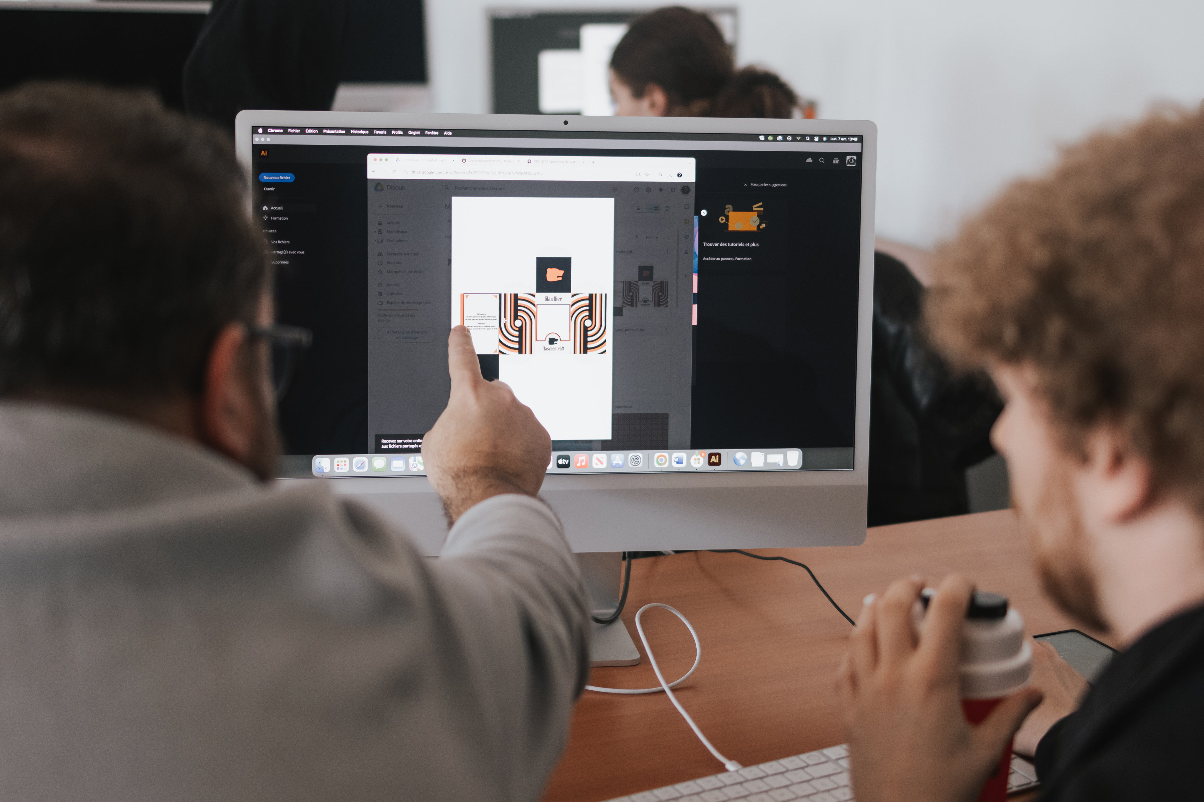 Un enseignant commente le travail d'un étudiant en design graphique dans le cadre d'un atelier à l'ÉdAC.