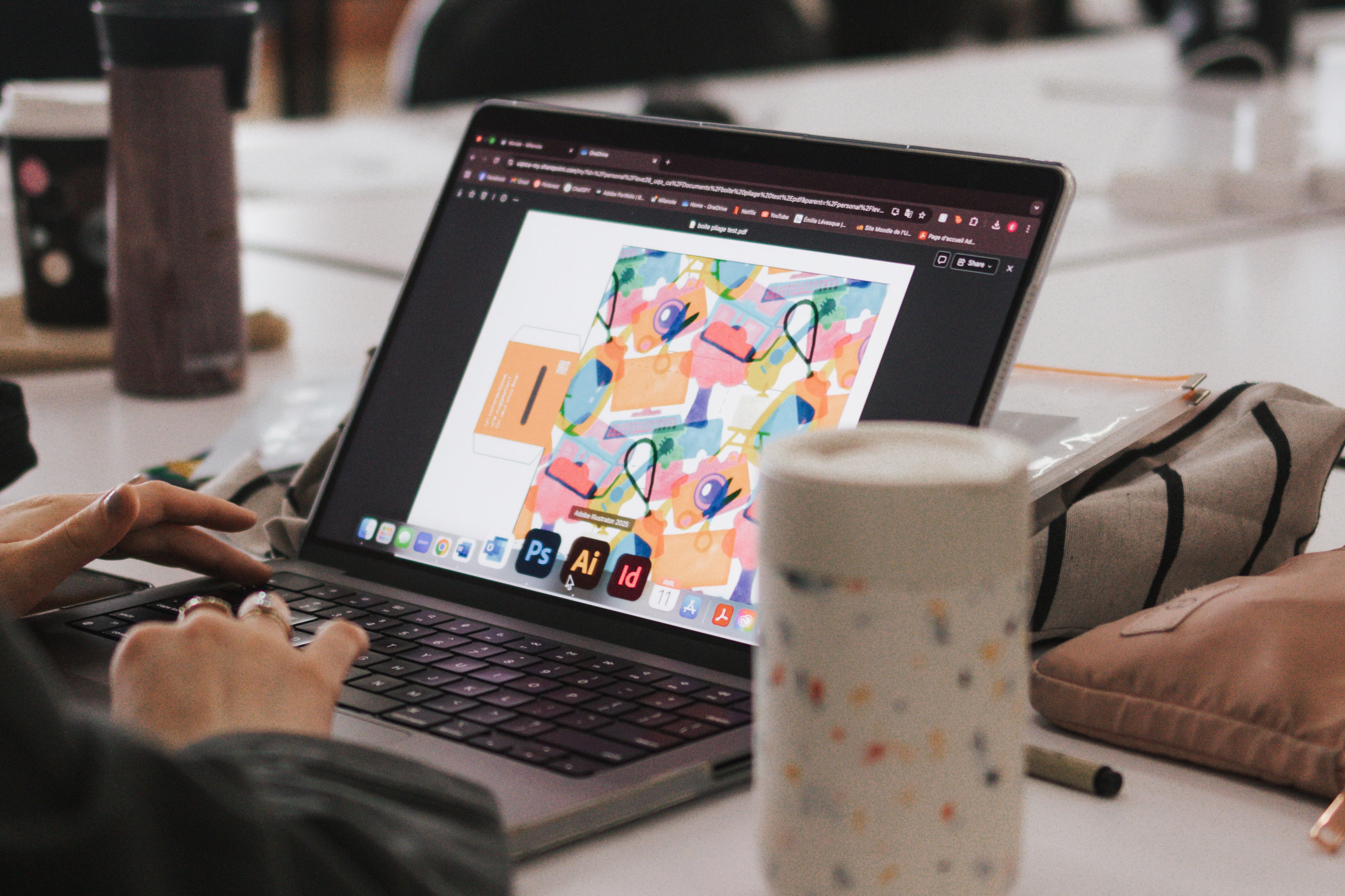 Une personne travaille sur son ordinateur dans un atelier de design graphique à l'ÉdAC.