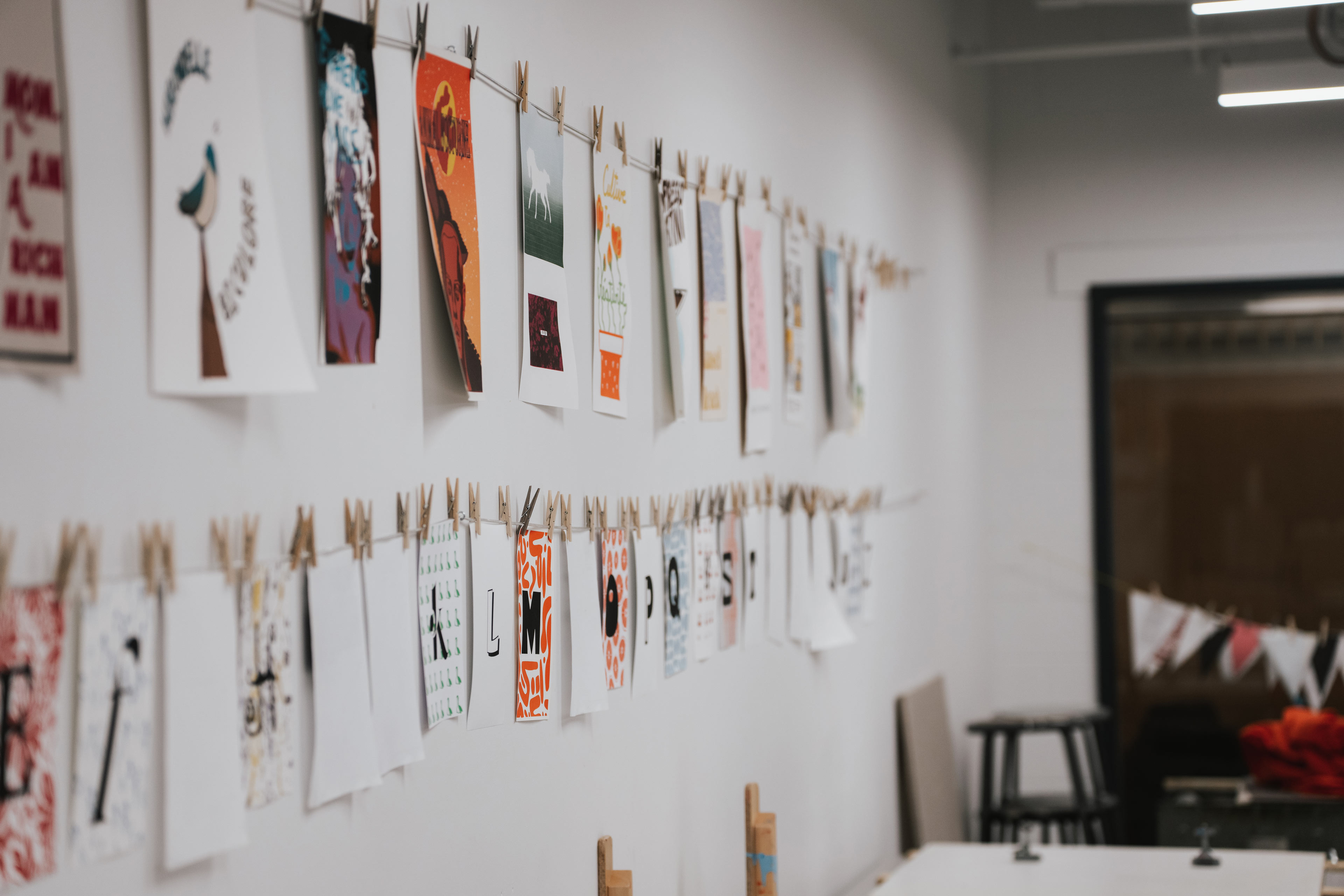 Des épreuves de sérigraphie sèchent sur une corde dans un atelier de l'ÉdAC.