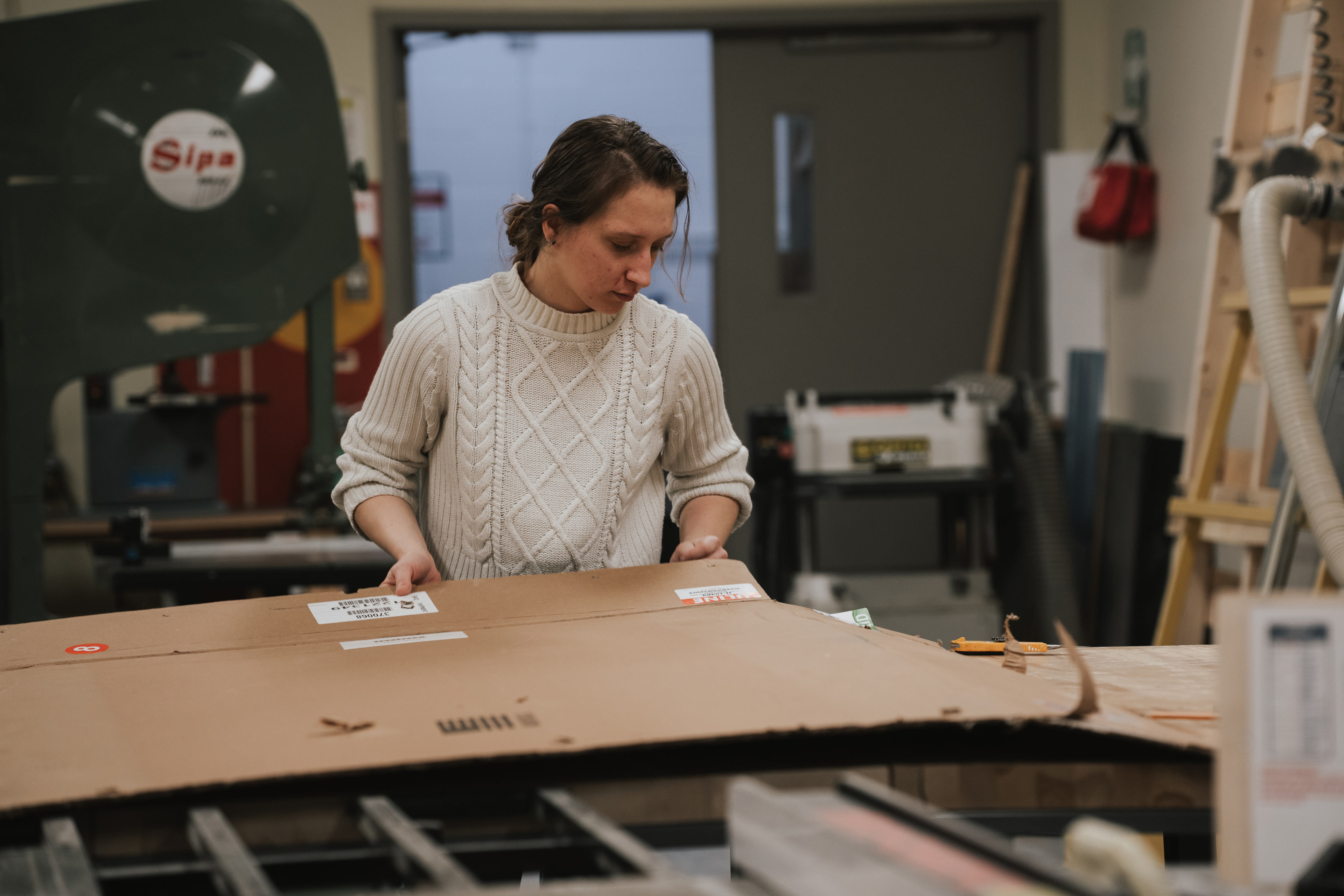 Une étudiante travaille sur une maquette dans un atelier de fabrication à l'ÉdAC.