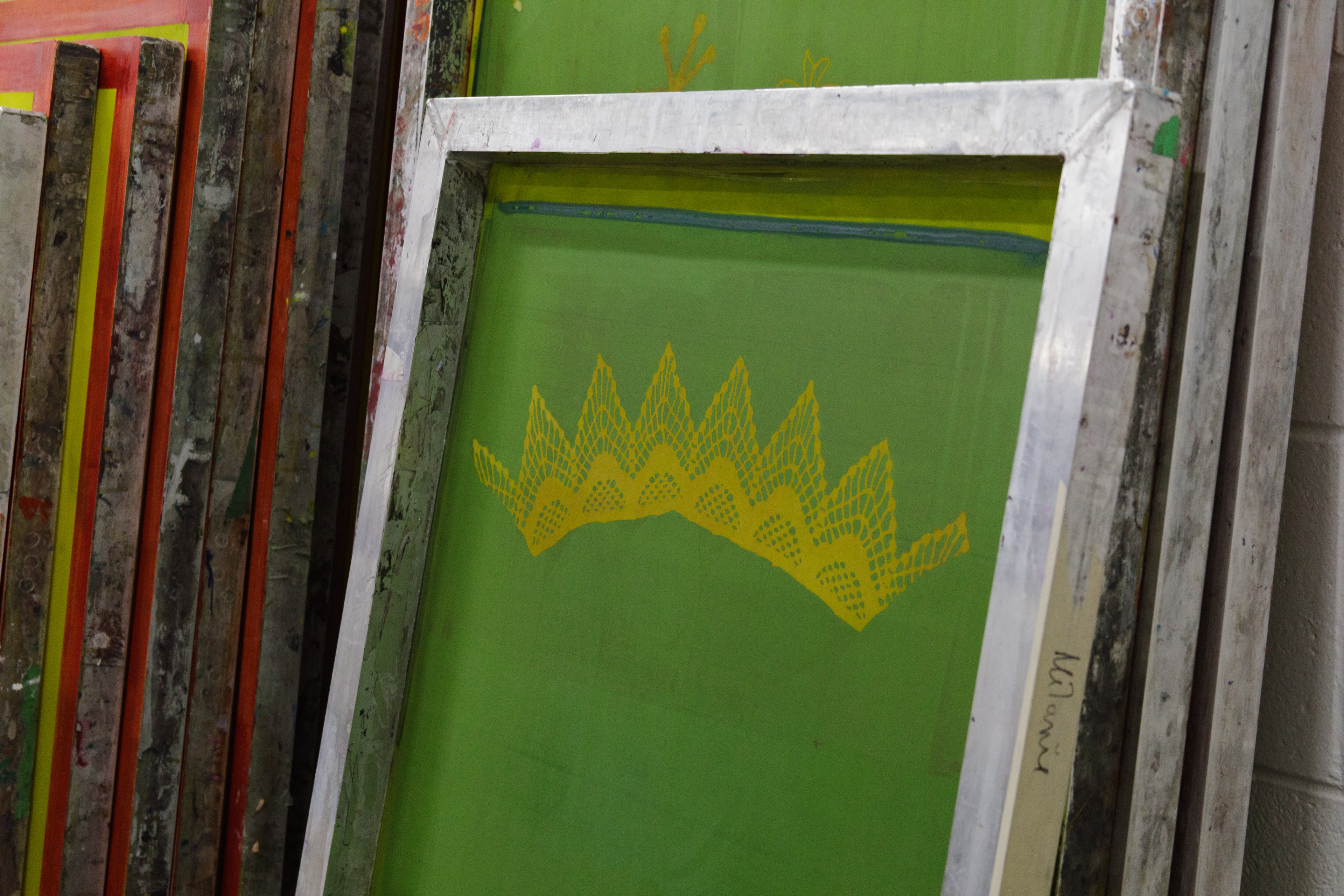 Des écrans de sérigraphie attendent contre un mur dans un atelier de l'ÉdAC.